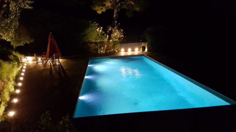 Swimming pool lit at night — ALK Lighting underwater pool lighting